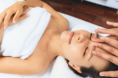 Kafkasyalı kadın stres önleyici kafa masajından ve lüks tatil beldesi ya da otel spa salonundaki modern ışık ortamında yüz güzelliği eğlencelerini şımartmaktan hoşlanıyor. Sessiz.