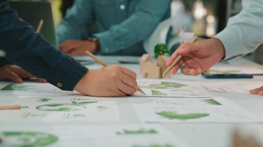 Profesyonellerin elleri, modern bir ofis masasına yayılmış doküman grafikleri ve grafikleri analiz ederek, takım çalışmasını ve stratejisini vurgulayarak, işbirlikçi bir toplantıda yer alıyor. SACTR