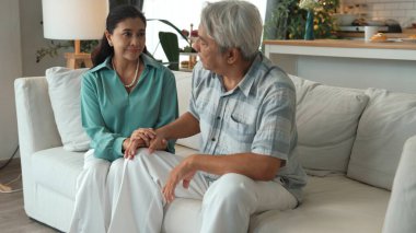 Stresli üst düzey yönetici günlük kıyafetleriyle baş ağrısı çekerken karısı da elini tutarak ona destek oluyor. Büyükannem ilgilenirken büyükbabamın çalışma sorunu vardı. Myrmidon.