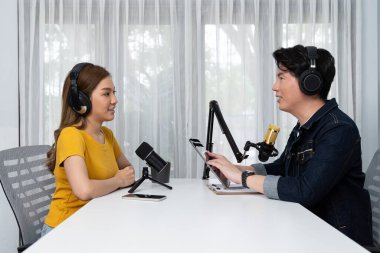 Gülümseyen radyo etkili sunucu elinde tablet, kulaklık takıyor kadın konuşmacı sosyal medya online canlı yayın kanalı ile röportaj yapıyor ve sabah stüdyo kaydında paylaşım linkini paylaşıyor. İnfobahn.