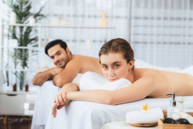 Lüks spa salonlarında sıcak mum ışığında cilt bakımı gören mutlu çift müşterisi. Sağlık kaplıcasında güzellik tedavisiyle tuz temizliği. Sessiz.