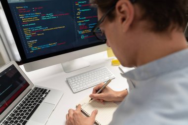 Stresli bilişim geliştiricisi deneme uygulamasında kodlama programı olan bilgisayar ve bilgisayar üzerinde çevrimiçi yazılım geliştirme bilgilerini analiz ediyor. Teknik mühendis önemli not listeleri yazıyor. Bireysel.