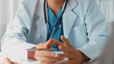 Hasta klinikte ya da hastane ofisinde doktor randevusuna gidiyor. Hastaların nabzını steteskopla kontrol edip risk faktörünü belirleyen doktor semptomları inceliyor. Ağır çekim. Katı.