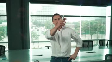 Akıllı iş adamı cam tahtanın önünde bir proje başlatmayı düşünüyor. Gülümseyen erkek proje yöneticisi yaratıcılık pazarlama stratejisini gösteren renkli yapışkan notlara bakıyor. Yönlendirici.