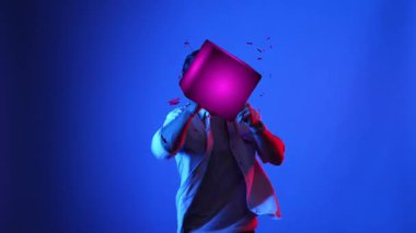 Meta evreni bağlamak için VR gözlük takarken yetenekli oyuncu boksörleri ve yüzen kutuları yumrukluyor. Erkek model, egzersiz yaparken ve neon arka planda dururken sanal gerçeklik gözlüğü kullanıyor. Aygıt.