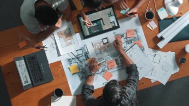 Pazarlama ekibi tasarım planlarken yöneticinin planlarını yukarıdan aşağıya incelemek. Mimar mühendisin birlikte çalıştığı, fikir paylaştığı ve proje planına not aldığı hava görüşü. Sempozyum.