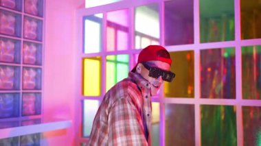 Kırmızı günlük gömlekli beyaz dansçı neon ışıkla enerjik dans ederken çeşitli şarkıcılar break dans ve serbest stil ve gece kulübünde kafiyeli müzik eşliğinde hareket ediyorlar. Mutluluk.