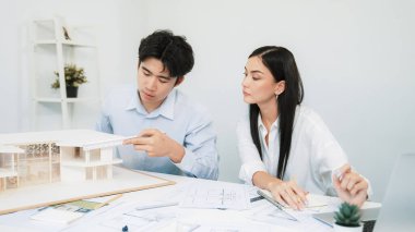 Profesyonel erkek mühendis ev modelini cetvel kullanarak ölçerken güzel bir kooperatif iş arkadaşı verileri analiz etmek için dizüstü bilgisayar kullanarak birlikte çalışıyor. Yaratıcı tasarım ve takım çalışması. - Yakın çekim. Tertemiz..