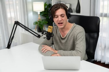 Sunucu kanalı, gülümseyen akıllı yayıncı kaydı, senaryosu ve akıllı telefonuyla sosyal medyada sohbet programı, kulaklık takarak modern ev stüdyosundaki video flamalarını kaydediyor. Bireysel.