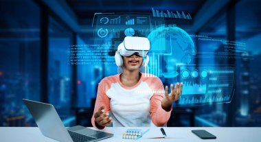 Masada ödev yaparken yapay zeka kullanarak metaevreleri birbirine bağlayan dizüstü bilgisayar ve artırılmış gözlük kullanan bir kız. Öğrenci holograma bakıyor ve bulanık ofiste oturuyor. Yaratıcılık.