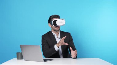 İş adamı bilgisayarla masada oturmuş yaratıcı fikirleri tartışıyor ve arttırılmış gerçeklik teknolojisi kullanarak online toplantıya katılıyor. Proje yöneticisi pazarlama stratejisini sunuyor. Aygıt.
