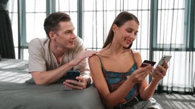 Genç çift, online ödeme uygulaması ve dijital cüzdanı kullanarak kredi kartıyla ödeme yaptıktan sonra mutlu ve heyecanlı hissediyorlar. Mobil internet üzerinden alışveriş ve modern alımlar. Düzenle