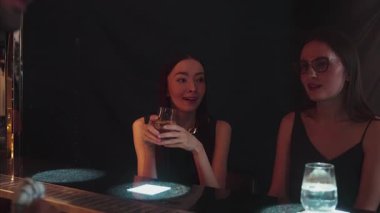 Güzel bir kadının VIP konuğunun portresi. Şık bir gece partisinde lüks bir gece kulübünde kadeh kaldırıyor. Barda oturmuş barmen atmosfer partisi yaşam tarzıyla konuşuyorum. Vinosity.