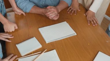 Kafkas öğretmeni ve çeşitli çocuklar başarılı bir projeyi kutlamak için el ele tutuşurken kağıt masaya saçıldı. Aşkı, şirketi, takım çalışmasını, birlikteliği ve birliği temsil et. Öğretim