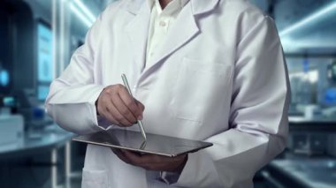 Stylus kalemle laboratuvarda yüzen tıbbi çapraz hologramı işaret ederken, doktorun tableti tutuş şeklini kapat. Pratisyen hekim teknolojiyi kullanarak ikonu kontrol ediyor ve bakıyor. İyileştirici.