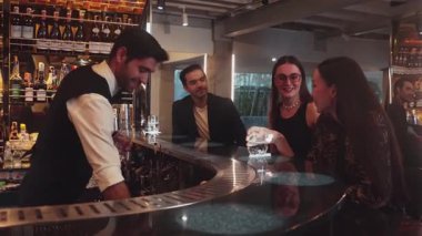 Gece kulübündeki lüks gece kulübünde, içki tezgahında çalışan akıllı barmen servisinde çift ya da arkadaş grubuyla gülen VIP müşterilere özel cin kokteyli servisi. Vinosity.