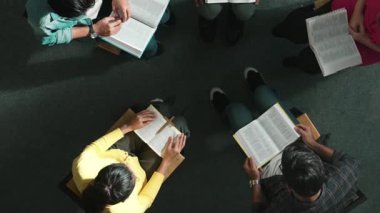 Katlanmış eller yaparken, kucağında haçla İncil okuyan duaların en üstteki görüntüsü. İnanç, güven ve umutla Tanrı 'ya dua eden farklı insanların havadan görünüşü. Ve daireler çizerek oturuyor. Sempozyum.