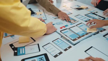Takım üyeleri dokunmatik ekran cihazları ve yaratıcı gelişim için yapışkan notlar kullanarak kullanıcı arayüzü kavramlarını tartışarak ve çizerek canlı bir çalışma alanında işbirliği yaparlar. SACTR