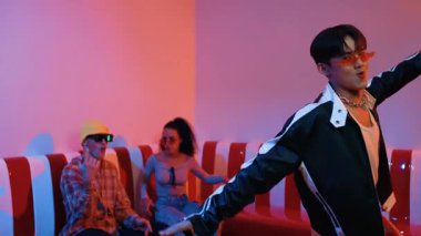 Asyalı bir adam pop müzikle dans ederken, çok kültürlü bir arkadaş evde ışık altında oturuyor. Çekici bir sokak dansçısı kameraya bakarken hip hop müzik dinliyor. Mutluluk.