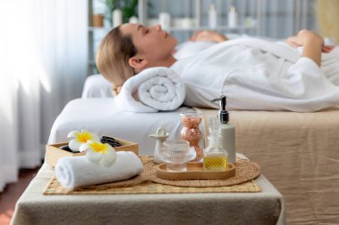 Aromaterapi masajı gündüz atmosferinde ya da spa salonunda bulanık bir kadına odak dekor ve spa aksesuarları kurarak tatil köyünde ya da otel arka planında keyifli aroma spa masajı yapan bir masaj. Sessiz.