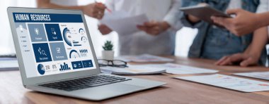 İnsan kaynakları yönetim yazılımı bilgisayar ekranında insan kaynakları çalışanlarının işe alım, maaş bordrosu, personel araması ve KPI değerlendirme çalışmalarını yönetmesine yardımcı oluyor