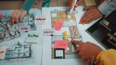 İç tasarıma ortak bir yaklaşım sergileyen canlı bir çalışma alanı. Eller yaratıcı ilham için etkin bir şekilde tasarım, renk örnekleri ve tasarım notlarıyla meşgul. SACTR