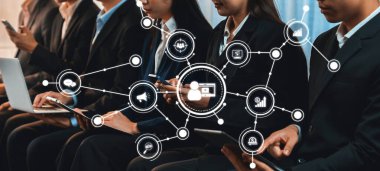 Asyalı iş başvurusu için başvuran kişi iş görüşmesi için bekleme odasında oturuyor. Ofis çalışanı ya da iş adamları dizüstü bilgisayar ve telefon kullanarak sıkışık bir odada birlikte çalışıyorlar. Alevli Dostluk