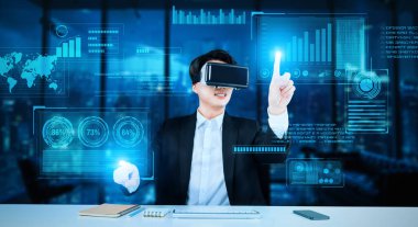 Profesyonel proje yöneticisi iş verilerine bakıyor ve onları tutuyor ve finansal tablolara bakıyor. Modern ofiste yapay zeka teknolojisi kullanarak gelişmiş gerçeklik gözlüğü takan zeki bir iş adamı. Yaratıcılık.