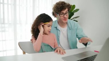 Baba, Amerikalı kız ekrana bakarken yapay zeka üretmeyi açıkla. Çekici beyaz bir baba, kızına kulaklıklı masada kod mühendisliği öğretiyor. Pedagoji.