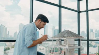 Tasarımlı ev modelini karşılaştıran profesyonel mimar mühendisi. İşadamı gayrimenkul projesine yatırım yapmaya karar verdi. Proje yöneticisi planla karşılaştırarak evi kontrol ediyor. İzleme