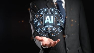 Bir iş adamı, elinde yapay zekanın görsel bir temsilini tutarak karanlık bir ortamda parlayan elementlere sahip bir beyni sergiliyor. XDMCP
