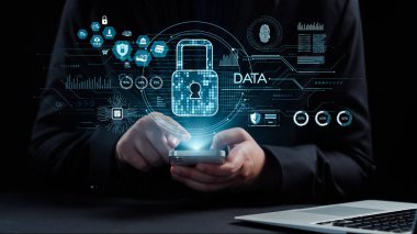 Yukarıda kilitlerin ve veri güvenliğinin grafik simgeleri görünürken, dijital gizlilik ve siber güvenlik konularını günümüzün teknoloji ortamında vurgulayan bir kişi akıllı telefonla etkileşim halindedir. Dörtgen