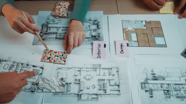 Mimari planlar, renkli malzemeler ve işbirliği ve yaratıcılıkla uğraşan ellerin yer aldığı dinamik bir iç tasarım projesi sunan çalışma alanı. SACTR