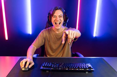 Kazanmak için çevrimiçi oyun oynayan akıllı flama makinesinin sunucu kanalı, neon ışıklı odada seçilen takım yarışması için izleyicilerle birlikte canlı yayında canlı yayında kulaklık takıyor. Bireysel.