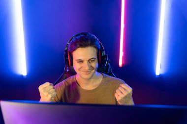 Kazanmak için çevrimiçi oyun oynayan akıllı flama makinesinin sunucu kanalı, neon ışıklı odada seçilen takım yarışması için izleyicilerle birlikte canlı yayında canlı yayında kulaklık takıyor. Bireysel.