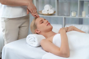 Kafkasyalı kadın stres önleyici kafa masajından ve lüks tatil beldesi ya da otel spa salonundaki modern ışık ortamında yüz güzelliği eğlencelerini şımartmaktan hoşlanıyor. Sessiz.