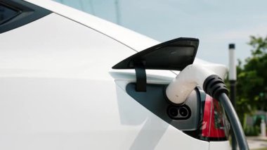 Green City Park 'taki otoparkta yavaş çekim EV elektrikli araba şarj bataryası. Sürdürülebilir ve çevre dostu şehir yolculuğu için yenilenebilir otomobil için alternatif temiz enerji teknolojisi. Yararlı
