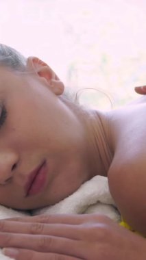 Rahat bir kadın profesyonel masaj terapistiyle lüks kaplıcalarda masaj yaptırıyor. Sağlık, şifa ve rahatlama konsepti.