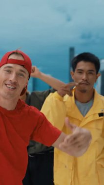 Bir grup hippi kameraya bakarken şehir manzaralı çatıda ellerini havaya kaldırıyor. Profesyonel break dansçı hip-hop müzikle dans ediyor. Açık hava sporu 2024 hiphop..