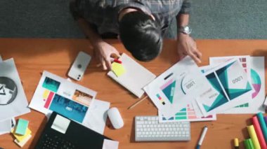 Toplantıda tasarımcı yazımının ve logo grafiklerinin zaman aşımı. Renkli paletler üzerinde çalışan iş adamlarının yakınlaşması ve masaya kağıt ve ekipman ile yapışkan notlar yazmak. Sempozyum.