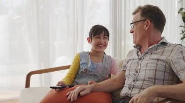 Büyükbaba ve torun birlikte TV 'de ilginç bir eğlence medyası izliyorlar. Eski üst düzey kullanım teknolojisi, genç nesil çapraz nesil ile iletişim kurarak aile bağlarını güçlendiriyor. Uyumsuzluk.