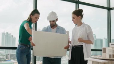 Proje planına bakarken tasarımla ilgili düşünen, paylaşan, beyin fırtınası yapan profesyonel mimar mühendis takımı. Yönetici planı dinlerken genç mimar plan yapıyor. İzleme