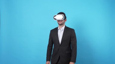 Yetenekli proje yöneticisi VR gözlük takıp online toplantıya katılırken pazarlama fikrini konuşuyor ve paylaşıyor. Zeki iş adamı mavi arka planda mali raporu birbirine bağlıyor. Aygıt.