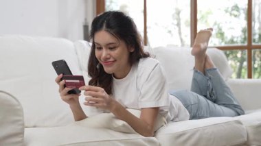 Kadın alışverişi ya da internet pazarında online ödeme modern yaşam tarzı için satılık eşyalar arıyor ve canlı siber güvenlik yazılımı tarafından korunan cüzdandan çevrimiçi ödeme için kredi kartı kullanıyor
