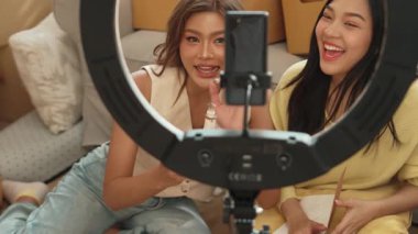 Oturma odasında canlı yayında ürün gösterilirken birkaç etkili kişi yayında. Evde ürün satarken blogger kaydeden çekici bir çift. Çevrimiçi pazarlama konsepti. Myrmidon.