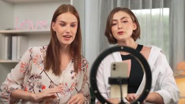 Etkilenen iki ortak canlı yayında video görüntülerini çekiyor makyaj malzemesi prim sosyal medya veya blog. Kozmetik stüdyosu ışıklandırmalı mutlu genç kız çevrimiçi pazarlama oturumu yayını için..