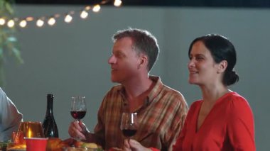 Emeklilik çifti, tatilde diğer aile üyeleriyle birlikte açık hava yemeğinde mutlu bir şekilde iyi haberlerden bahsediyorlar. İletişim eski ve genç nesil arasındaki aile bağını güçlendirir. Uyumsuzluk.