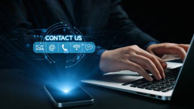 Yakınlarda akıllı bir telefonla dizüstü bilgisayarda yazan ve gelecekteki bir arayüz üzerinden çeşitli iletişim seçeneklerini gösteren canlı bir dijital iletişim sahnesi. Dörtgen