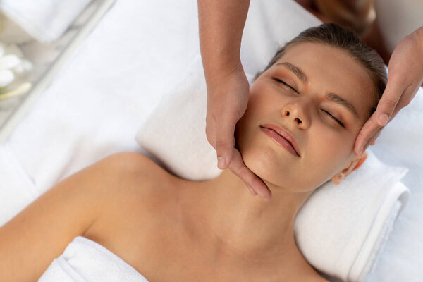 Panorama top view of woman enjoying relaxing anti-stress head massage and pampering facial beauty skin recreation leisure in dayspa modern light ambient at luxury resort or hotel spa salon. Quiescent