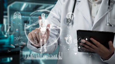 Doktorun elinde tablet varken ve laboratuvarda yüzen insan anatomisi hologramına bakarken. Semptomu teşhis ederken ve tıbbi verilerle çalışırken teknoloji yeniliklerini kullanan bir tıp çalışanı. İyileştirici.